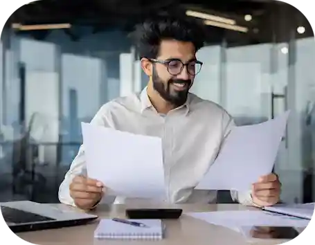 man with glasses holding paperwork while examining