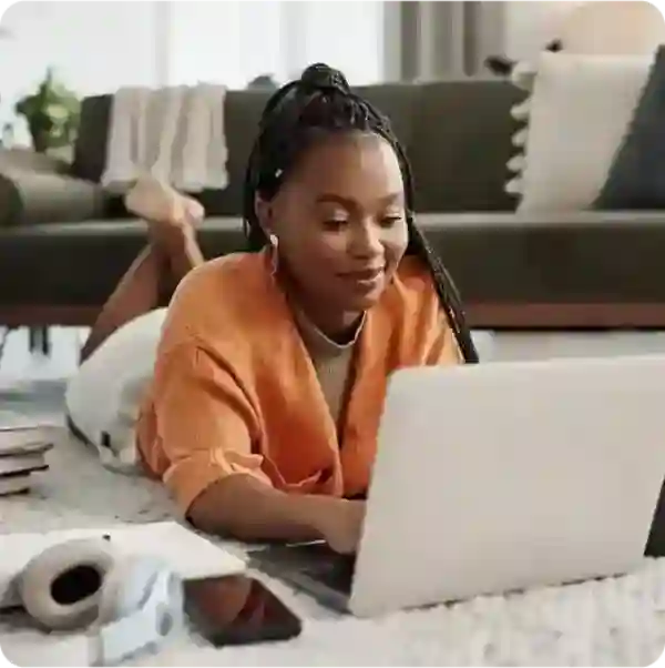 Woman working on her laptop resting on the floor